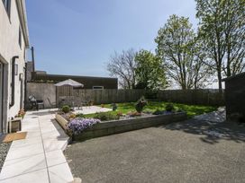 A garden with a table and chairs under an umbrella at La Bastille in Maenclochog