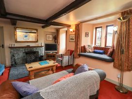 A living room with a fireplace and television at Tethera Cottage in Bampton, Cumbria