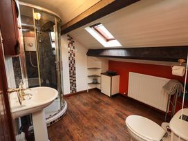A bathroom with shower, sink and toilet at Tethera Cottage in Bampton, Cumbria