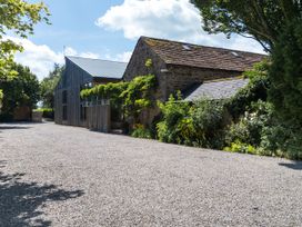 An outdoor area with gravel and buildings at Cedrus Lodge in Skelton near Penrith