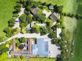 An aerial view of a property with houses and trees at Cedrus Lodge in Skelton near Penrith