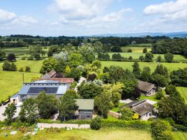 An aerial view of a property surrounded by fields and trees at Cedrus Lodge in Skelton near Penrith