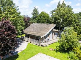 An outdoor view of a cabin surrounded by trees at Larch Lodge in Skelton near Penrith
