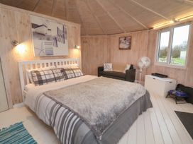 A bedroom with a double bed a couch a fan and a window at Blackpool Mill near Hartland