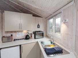 A small kitchen with a sink a window cabinets a toaster kettle and a toaster oven at Berry Bay near Hartland