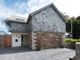 A house with stone wall and shingle roof at Pentire in St Minver