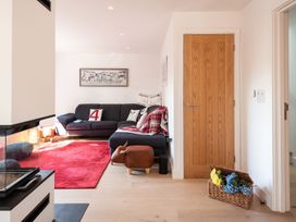 A living room with a sofa and a door at Pentire in St Minver
