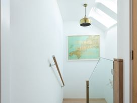 A staircase with a light fixture and a framed map at Pentire St Minver