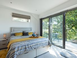 A bedroom with a bed and a balcony at Pentire St Minver