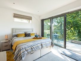 A bedroom with a bed and access to a balcony at Pentire in St Minver