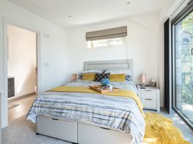 A bedroom with a bed and nightstand at Pentire in St Minver