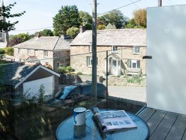 An outdoor area with a table, mug and magazine at Pentire in St Minver