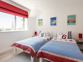 A bedroom with two beds and wall art at Pentire, St Minver