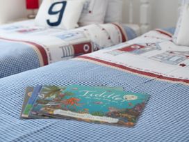 A bedroom with two beds and children's books on the cover at Pentire in St Minver