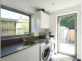 A laundry room with washing machine and sink at Pentire in St Minver