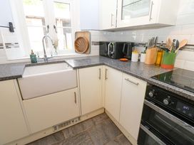 A kitchen corner with a farmhouse sink microwave kettle knife block and cooking utensils at 3 Railway Cottages in Long Marton near Appleby-In-Westmorland