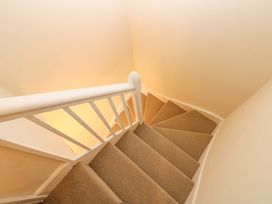 A narrow carpeted staircase with white wooden railing at 3 Railway Cottages Long Marton near Appleby-In-Westmorland