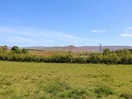A grassy field with a fence and hills in the background at 3 Railway Cottages in Long Marton near Appleby-In-Westmorland