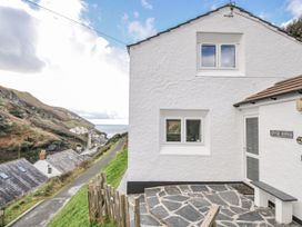 An exterior view of a house with a path and sea at Little Ruffo in Trebarwith near Tintagel