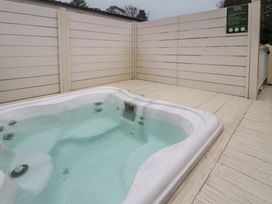 A hot tub on wooden decking at Woodlands Gold (WO 41) Ruthin