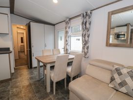 A dining room with a table and chairs at Woodlands Gold (WO 41) Ruthin