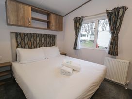 A bedroom with a double bed and window at Woodlands Gold (WO 41) in Ruthin
