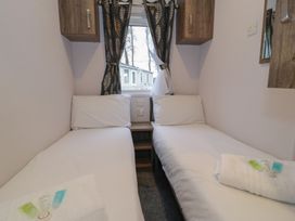 A bedroom with two single beds and a window at Woodlands Gold (WO 41) Ruthin