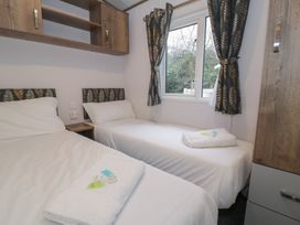 A bedroom with two beds and a window at Woodlands Gold (WO 41) in Ruthin