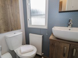 A bathroom with a toilet and sink at Woodlands Gold (WO 41) in Ruthin