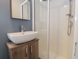 A bathroom with a washbasin and shower at Woodlands Gold (WO 41) in Ruthin