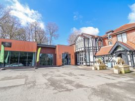 An entrance area with decorative lions and a sign at Woodlands Gold (WO 41) Ruthin