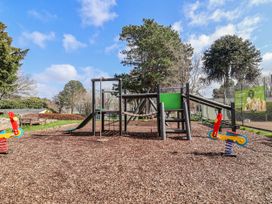 A playground with climbing frame and slide at Woodlands Gold (WO 41) in Ruthin