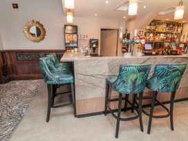 A bar area with stools and shelves of bottles at Woodlands Gold (WO 41) in Ruthin