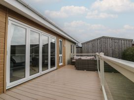 A deck area with sliding doors and outdoor furniture at Platinum Lodge (503) Talybont