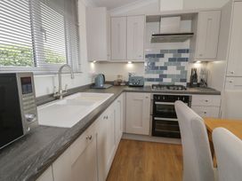 A kitchen with appliances and a dining table at Platinum Lodge (503) Talybont