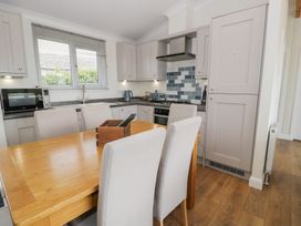 A kitchen with a dining table and chairs at Platinum Lodge (503) Talybont