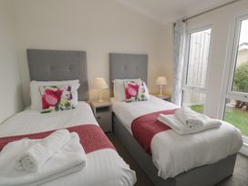 A bedroom with two single beds and a nightstand at Platinum Lodge (503) Talybont