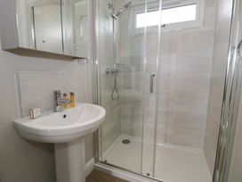 A bathroom with a shower and sink at Platinum Lodge (503) Talybont