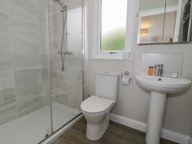A bathroom with a shower, toilet, and sink at Platinum Lodge (503) Talybont