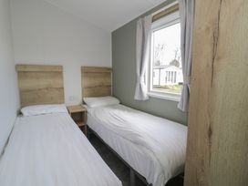 A bedroom with two single beds and a window at Lido Silver Plus 111 Prestatyn