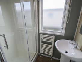 A bathroom with a shower and washbasin at Lido Silver Plus 111 Prestatyn