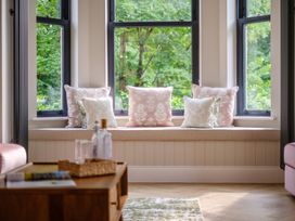 A living room with cushions on a window seat at Riverside in Ambleside