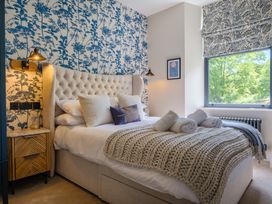 A bedroom with a bed, nightstand, and window at Riverside in Ambleside