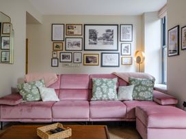 A living room with a pink sofa and framed pictures at Riverside in Ambleside