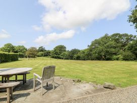 A garden with a table and chair overlooking a grassy area at Plas Pontfaen near Fishguard and Newport, Pembrokeshire