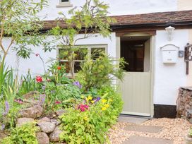 A garden with a door and flowers at 1 Myrtle Cottages Stokeinteignhead