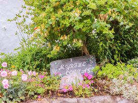 A garden with a sign and flowers at 1 Myrtle Cottages Stokeinteignhead