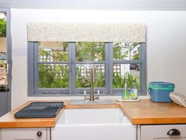 A kitchen with a window and sink at 1 Myrtle Cottages in Stokeinteignhead
