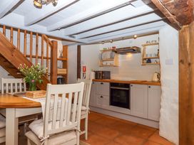 A kitchen with a dining area and stairs at 1 Myrtle Cottages Stokeinteignhead
