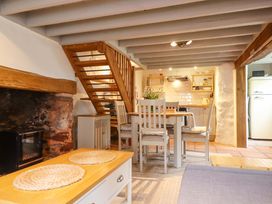 A kitchen with dining table and staircase at 1 Myrtle Cottages Stokeinteignhead